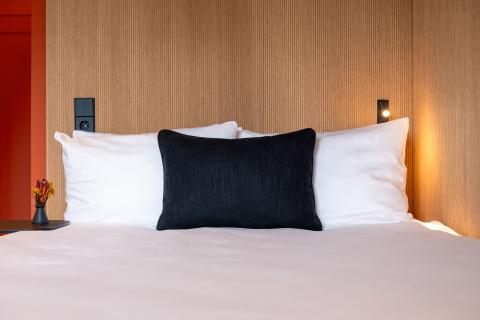 Front view of a hotel bed with black and white pillows
