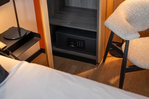 Details of a hotel bed, armchair and bedside table