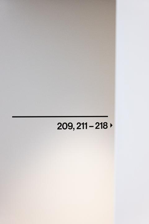 Black printed room numbers as signposts in Schwabing hotel
