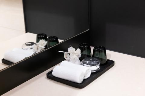 Two water glasses and small towels next to the sink of a bathroom