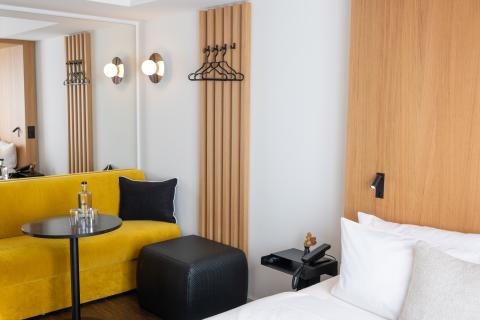 Hotelzimmer mit gelbem Sofa, Doppelbett in schwarzen und gelben Farben
