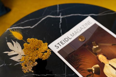 Details eines Steidl Magazins auf einem schwarzen runden Marmortisch