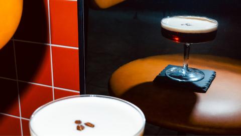 Details of an espresso martini in front of a mirror