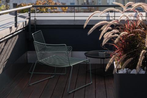 Sonnendurchflutete Terrasse mit Stühlen und Pflanzen