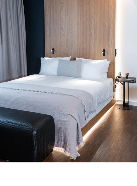 Double bed with footboard illuminated floor in the room of a hotel in Schwabing